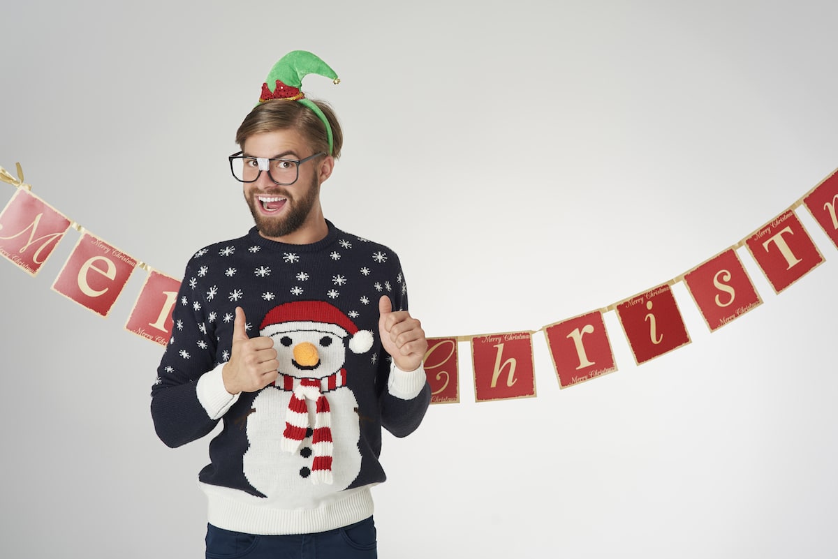 Ein weihnachtlich gekleideter Student gibt zwei Daumen nach oben, weil sein Advent-Deko in seiner Studierenden-WG mit diesen DIYs so gut gelungen ist.