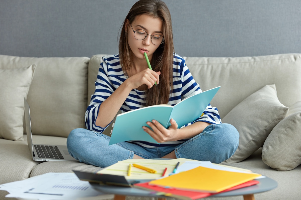 Eine Studentin ist neben dem Studium als Freelancerin selbstständig und Arbeit von der Couch aus.